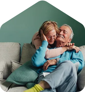A man and a woman hugging on a couch.