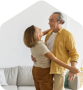 A man and a woman dancing together in a living room.