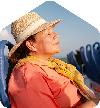 A woman wearing a hat and scarf sitting in a chair.