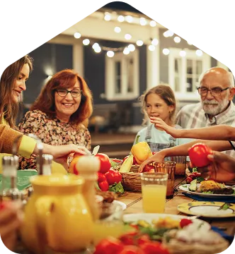 A group of people sitting around a table with food.