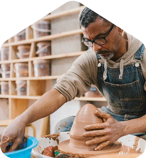 A man is making a vase out of clay.